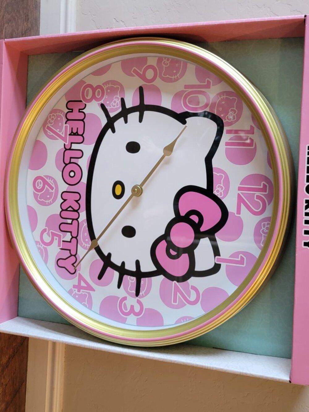 Hello Kitty Analog Wall Clock featuring a gold trim and pink polka-dot face has